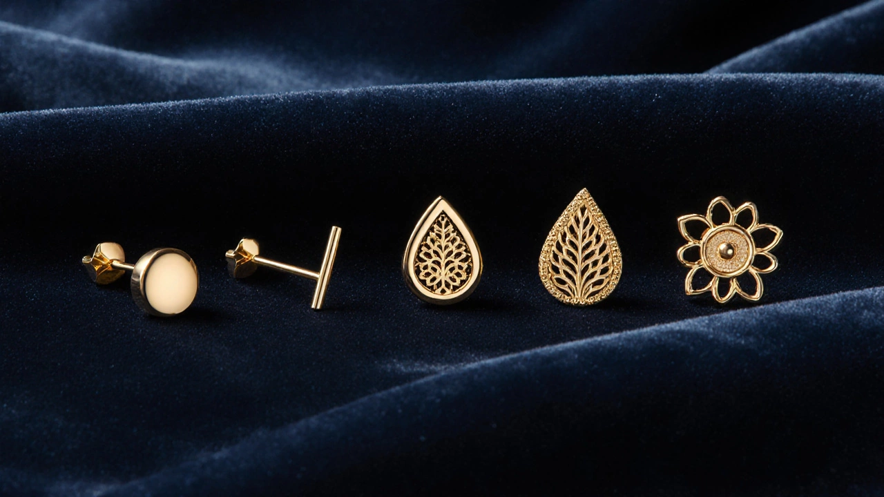 Flat‑lay of five different gold stud earrings on velvet, showing round, bar, teardrop, filigree, and leaf designs.